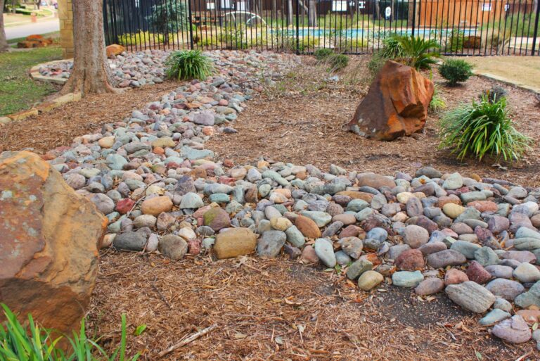 Landscaping with a dry stream and using river rock to accent garden