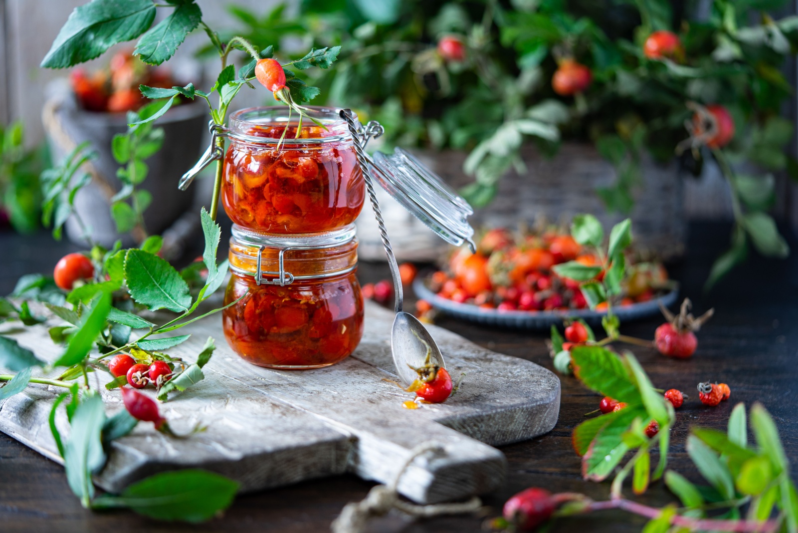 Rose hip jam in jar pots on wooden board