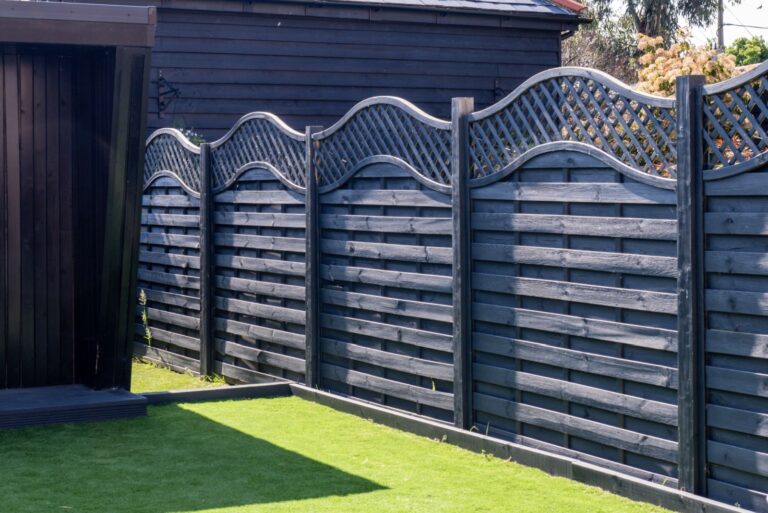 tall Black wooden garden fence with a fancy trellis