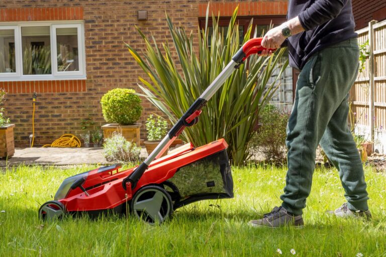 gardener cutting a lawn using a lawn mower