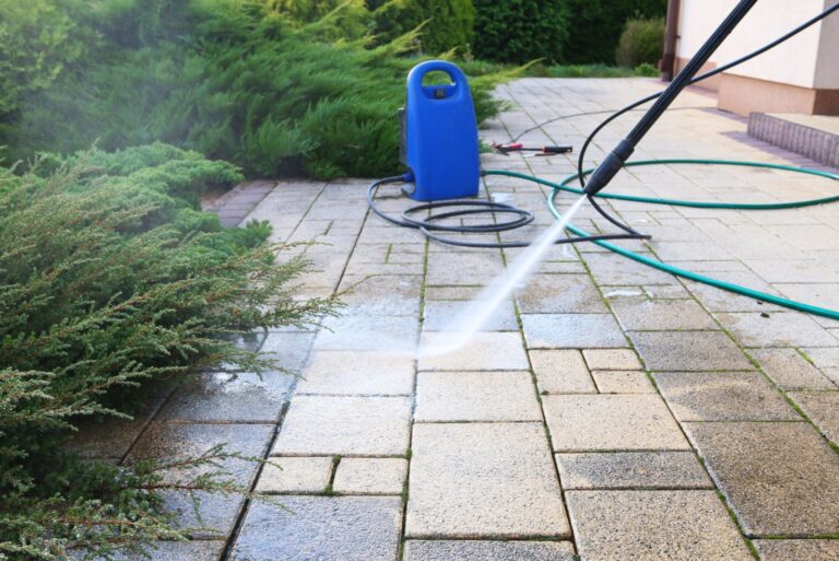 cleaning dirty paving stones in the garden with a pressure washer