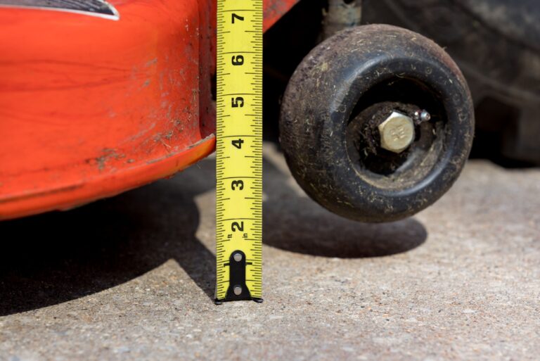 Lawn mower deck and anti-scalp gauge wheel with tape measure checking height adjustment