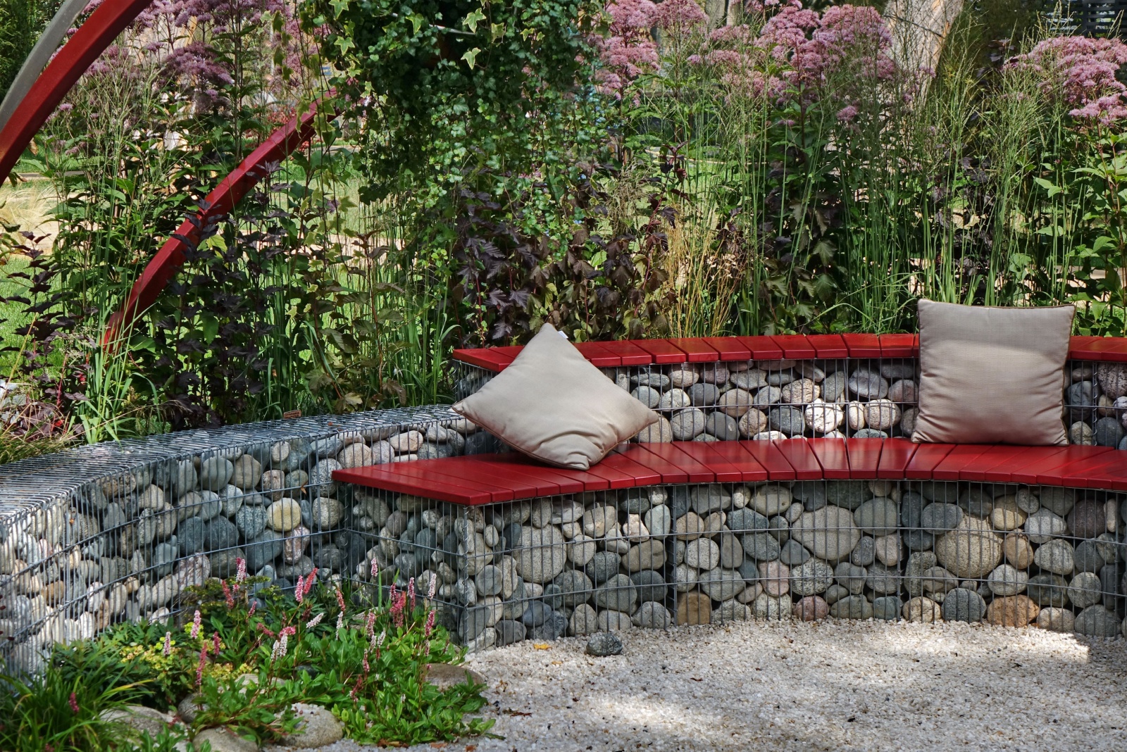 gabion wall with wooden seat in backyard