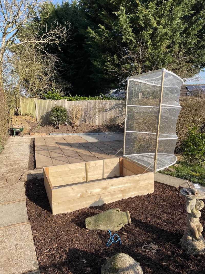 Clipping The Fabric To Wooden Raised Bed Frames With Binder Clips